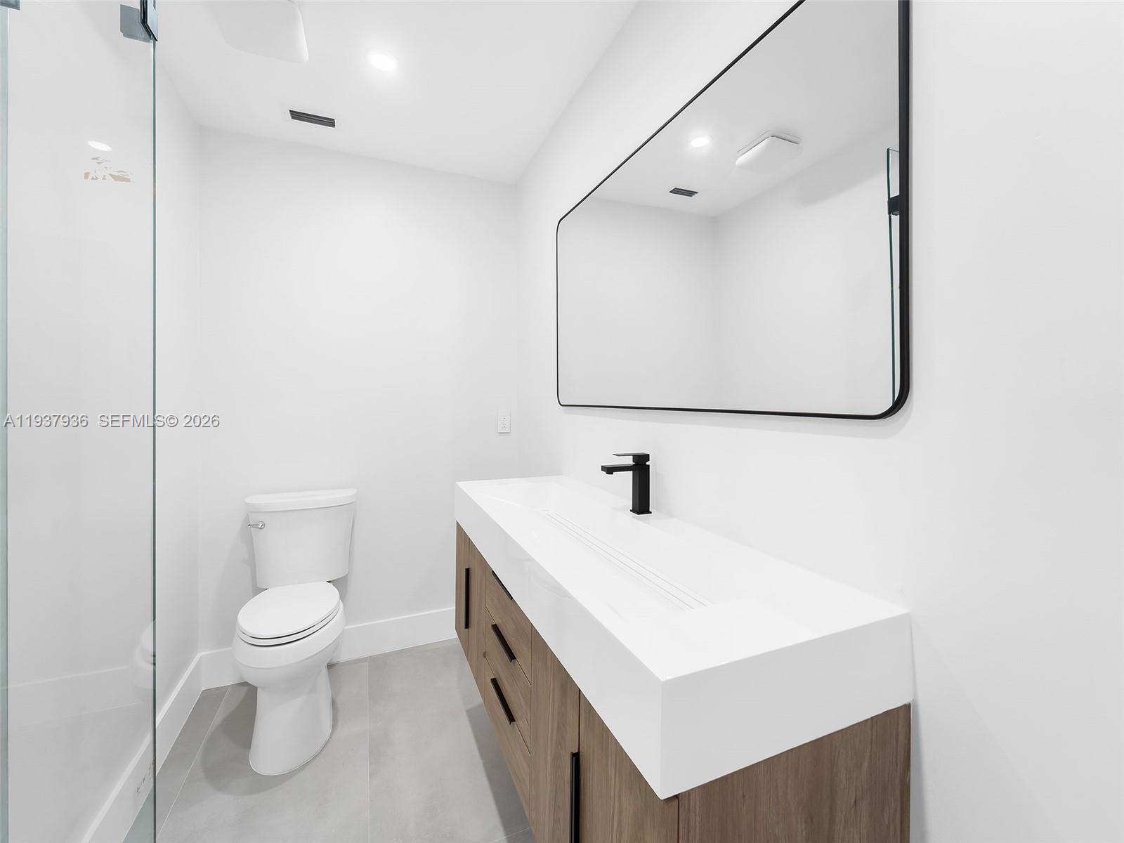 212 Southwest 7th Street Hallandale Beach, FL 33009 - Photo 7 of 23 a bathroom with a sink a toilet and a mirror