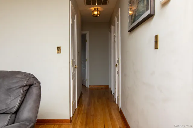 a view of a hallway with wooden floor and stairs