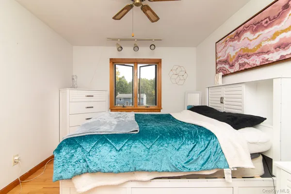 a bedroom with a bed and a painting on the wall