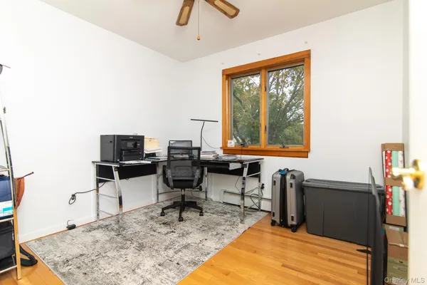 a view of a workspace with furniture and a window