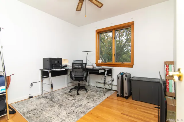 a view of a workspace with furniture and a window