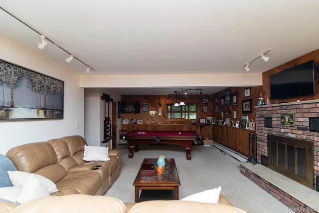 a living room with furniture and a pool table