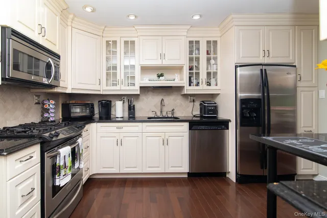 a kitchen with stainless steel appliances granite countertop a refrigerator stove top oven and sink