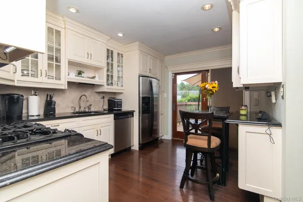 a kitchen with stainless steel appliances granite countertop a refrigerator stove microwave and sink