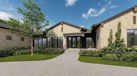 a front view of a house with a yard and potted plants