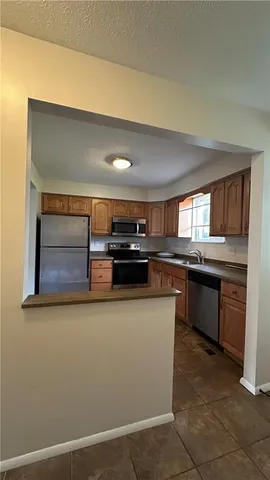 a kitchen with granite countertop a refrigerator and a stove