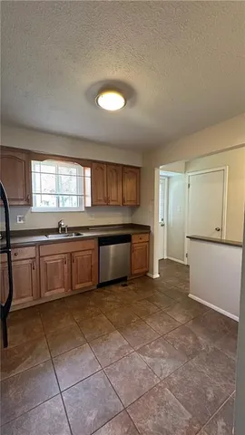 a large kitchen with a stove a sink dishwasher and a refrigerator