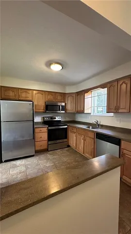 a kitchen with stainless steel appliances granite countertop a sink and a stove
