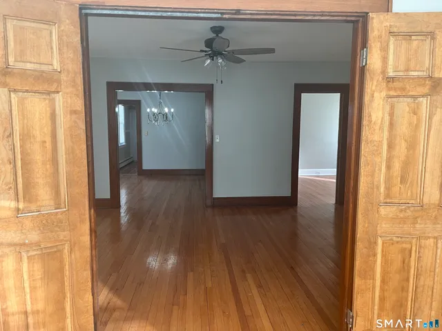 a view of a hallway with wooden floor and a window