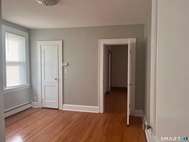 an empty room with wooden floor and closet
