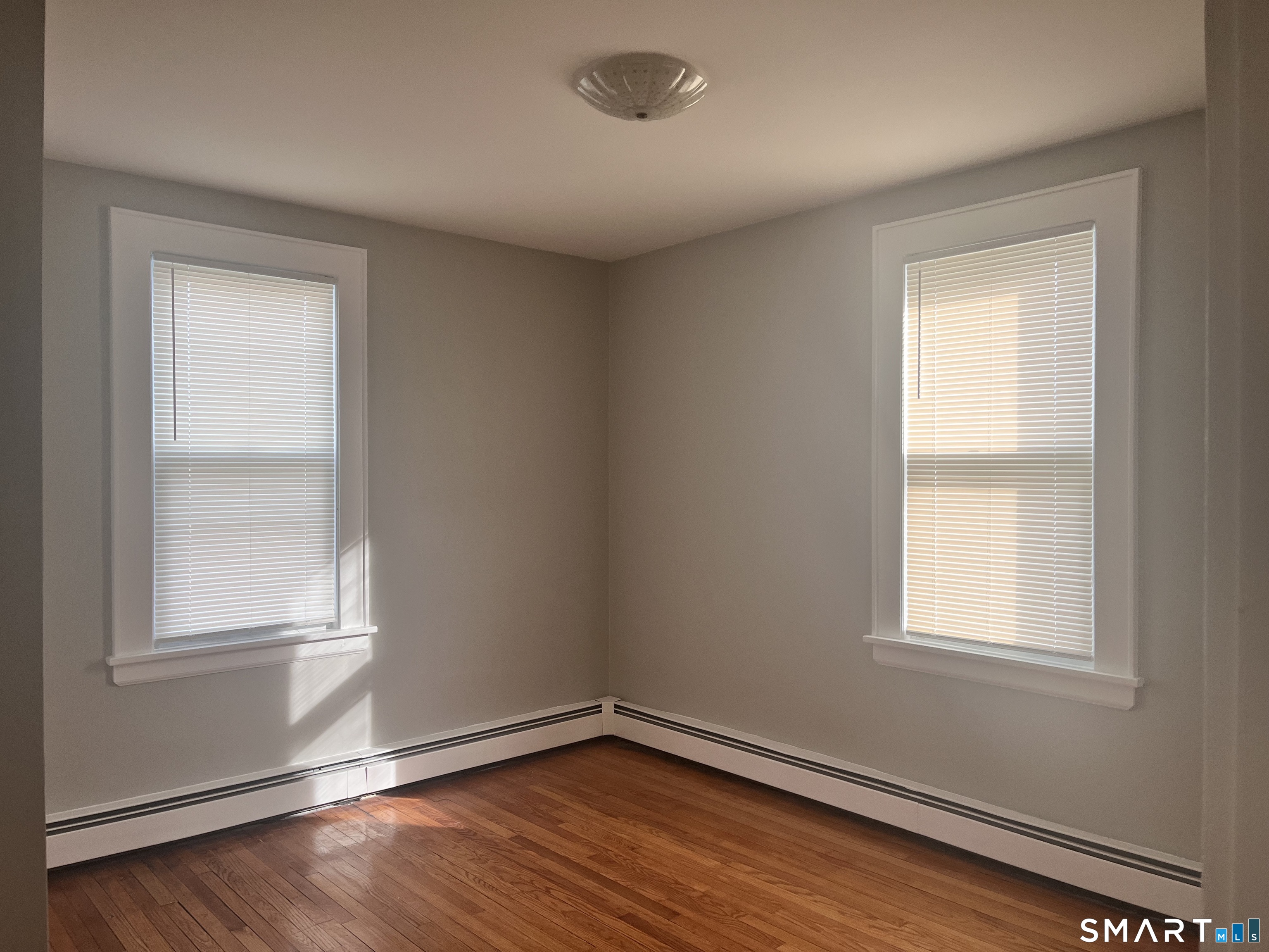 460 Anson Street Bridgeport, CT 06606 - Photo 15 of 24 an empty room with wooden floor and windows