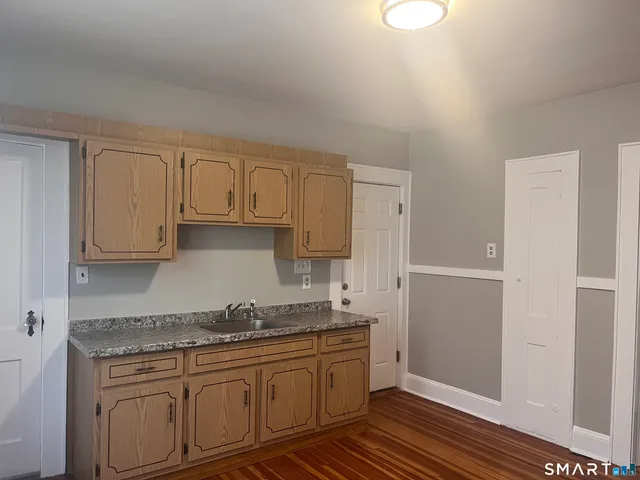 a kitchen with granite countertop white cabinets and stainless steel appliances