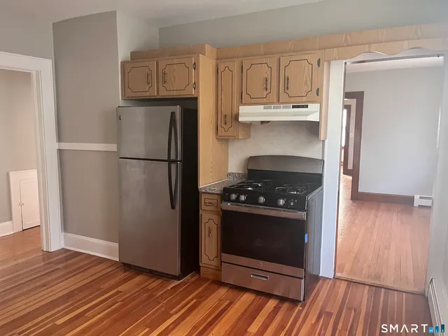 a kitchen with wooden floors and appliances