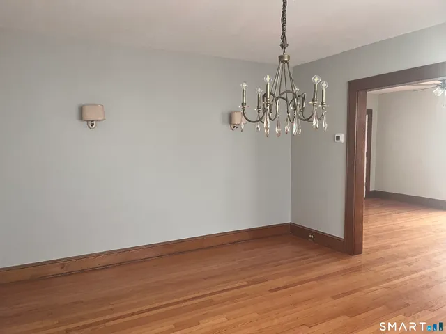 a view of a chandelier in big room with wooden floor