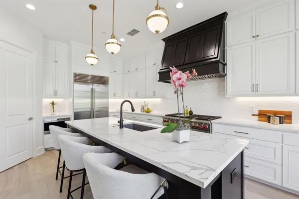 a very nice looking kitchen with a kitchen island a sink a table and chairs