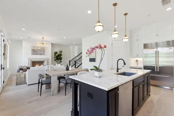a kitchen with stainless steel appliances granite countertop a sink a stove and a wooden floors