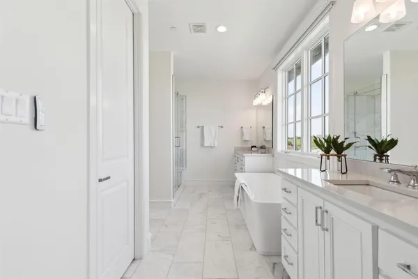 a spacious bathroom with a tub sink and mirror