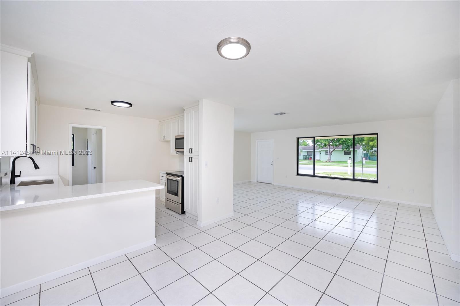 532 Northwest 15th Street Homestead, FL 33030 - Photo 17 of 32 a view of a kitchen with a sink dishwasher and a refrigerator
