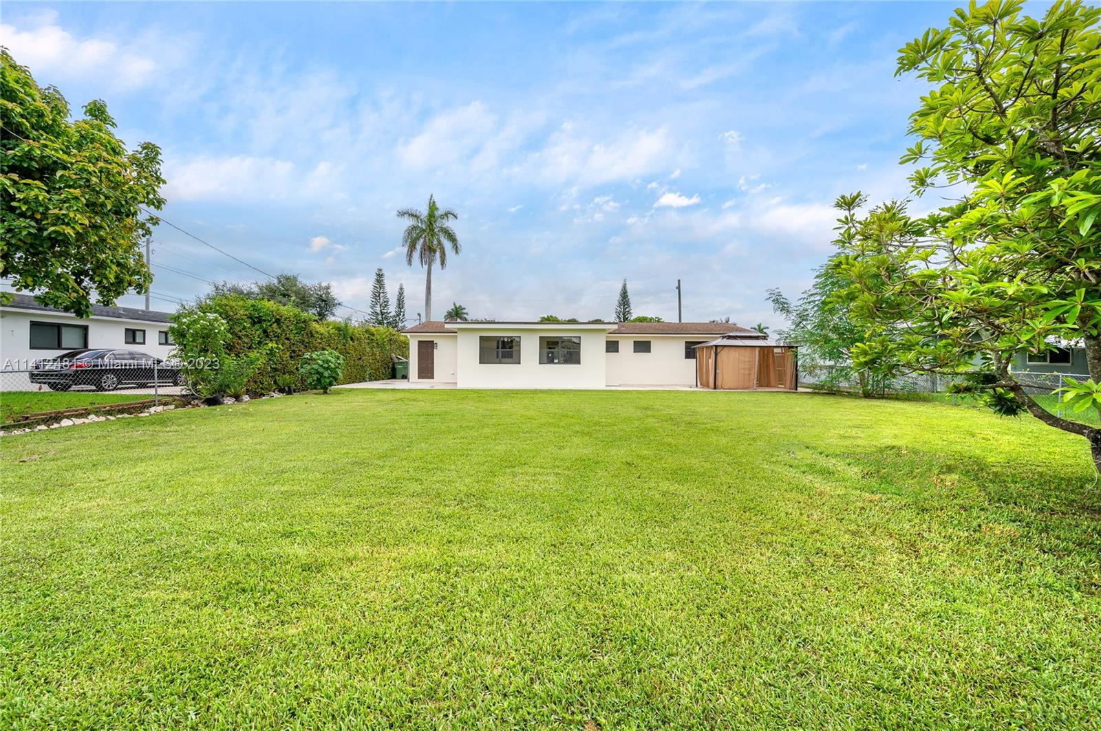 532 Northwest 15th Street Homestead, FL 33030 - Photo 5 of 32 a white house with a big yard and large trees