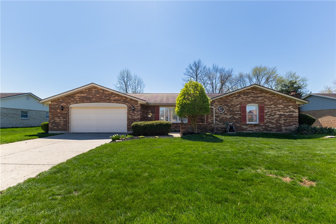 This brick ranch home offers a welcoming facade with an attached garage and well-maintained landscaping.