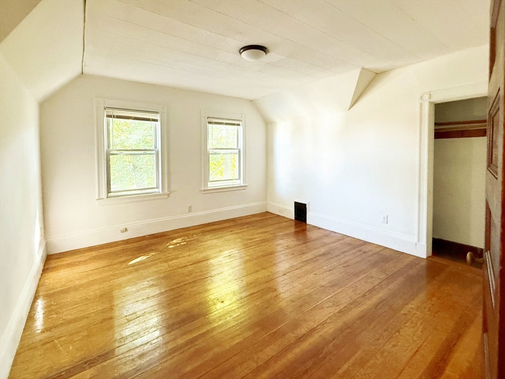 582 Cambridge Street, Unit 3 Boston, MA 02134 - Photo 2 of 6 a view of an empty room with wooden floor and a window