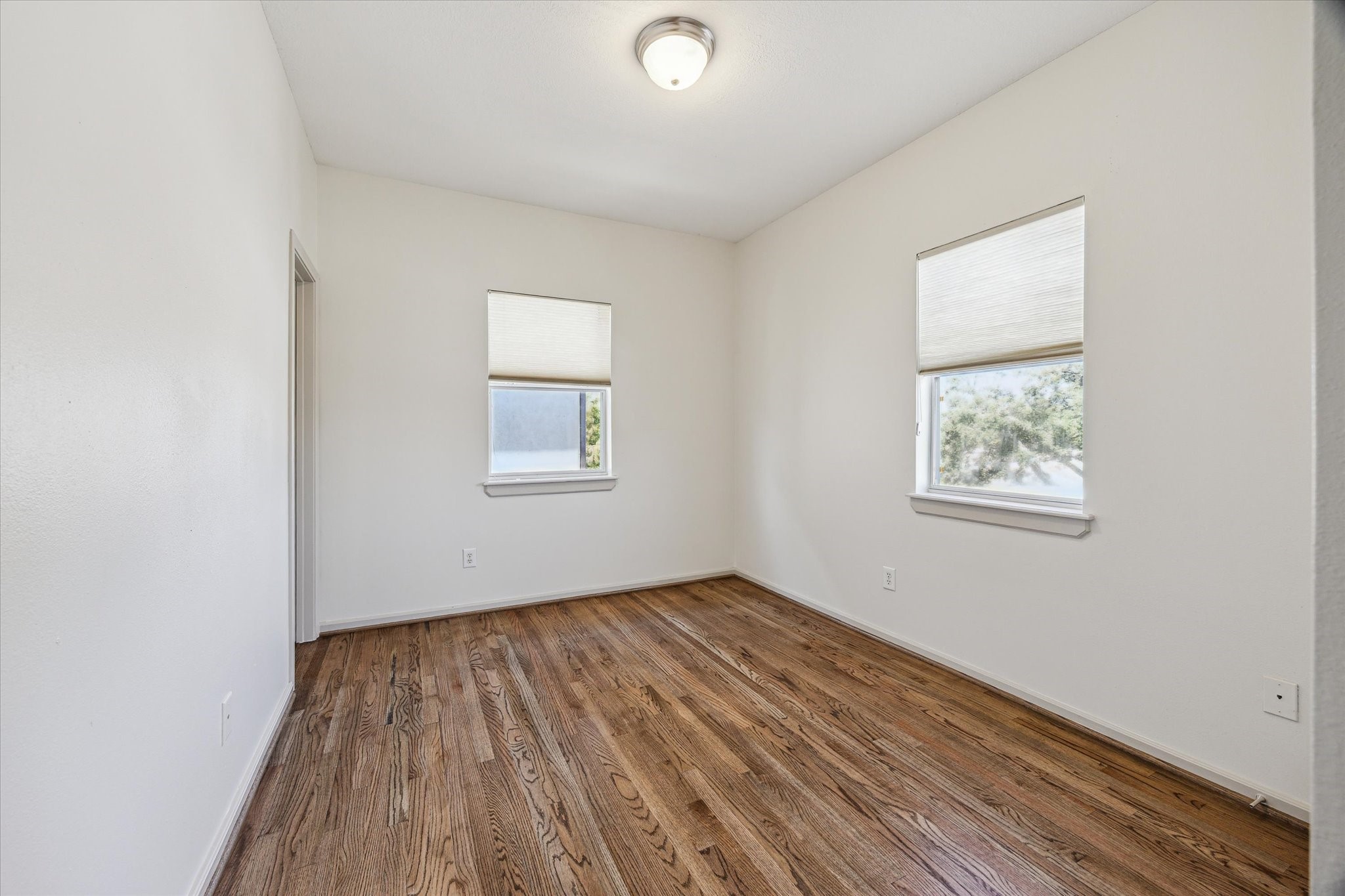 5334 Kiam Street, Unit C Houston, TX 77007 - Photo 19 of 23 an empty room with wooden floor and windows