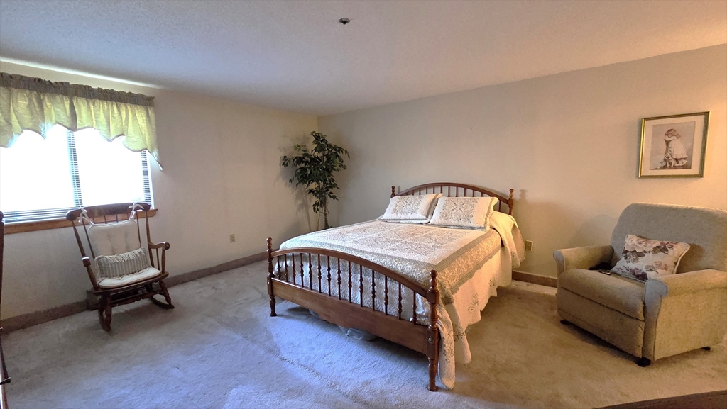 200 Burkhall Street, Unit 102 Weymouth, MA 02190 - Photo 11 of 25 a bedroom with a bed chair and window