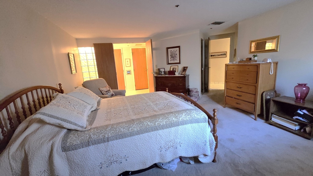 200 Burkhall Street, Unit 102 Weymouth, MA 02190 - Photo 12 of 25 a spacious bedroom with a bed and wooden floor