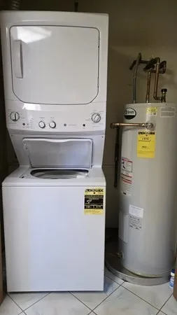 a view of washer and dryer with kitchen in the background
