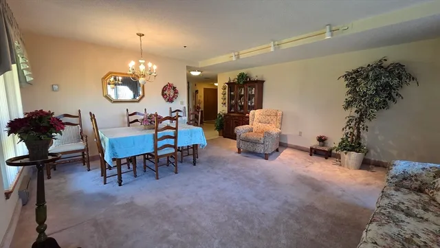 a view of a dining room with furniture and chandelier