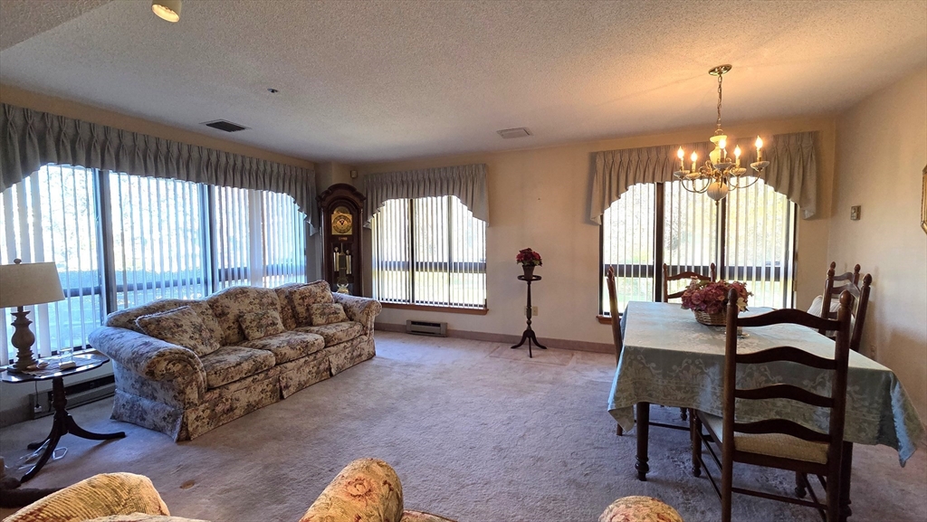 200 Burkhall Street, Unit 102 Weymouth, MA 02190 - Photo 5 of 25 a living room with furniture and a large window