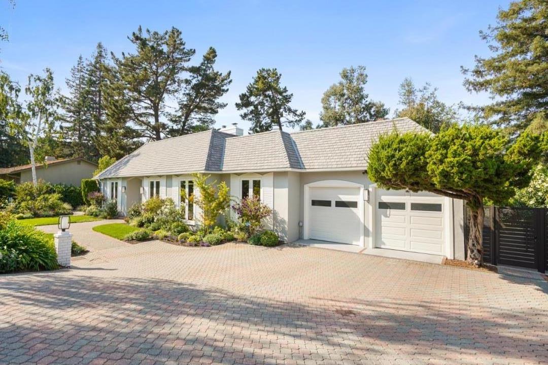 a front view of a house with a yard and potted plants