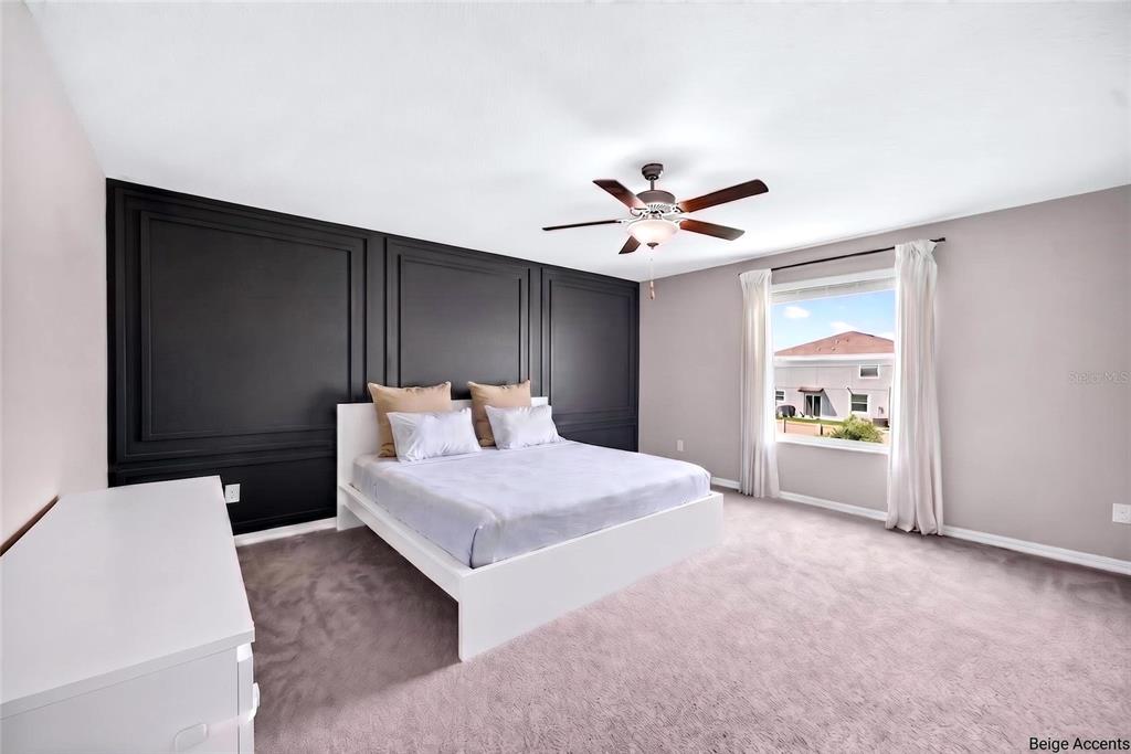 31724 Sun Kettle Loop Wesley Chapel, FL 33545 - Photo 4 of 49 a spacious bedroom with a bed and a chandelier