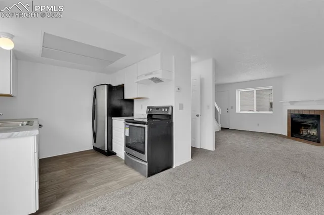 a view of a kitchen with stainless steel appliances wooden floor and a window