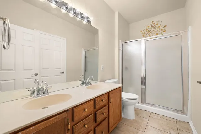 a bathroom with a double vanity sink mirror and toilet