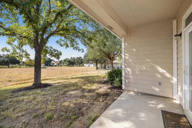 a view of a yard with an tree and wooden fence