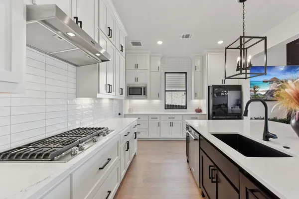 a kitchen with stainless steel appliances granite countertop a sink a stove and cabinets