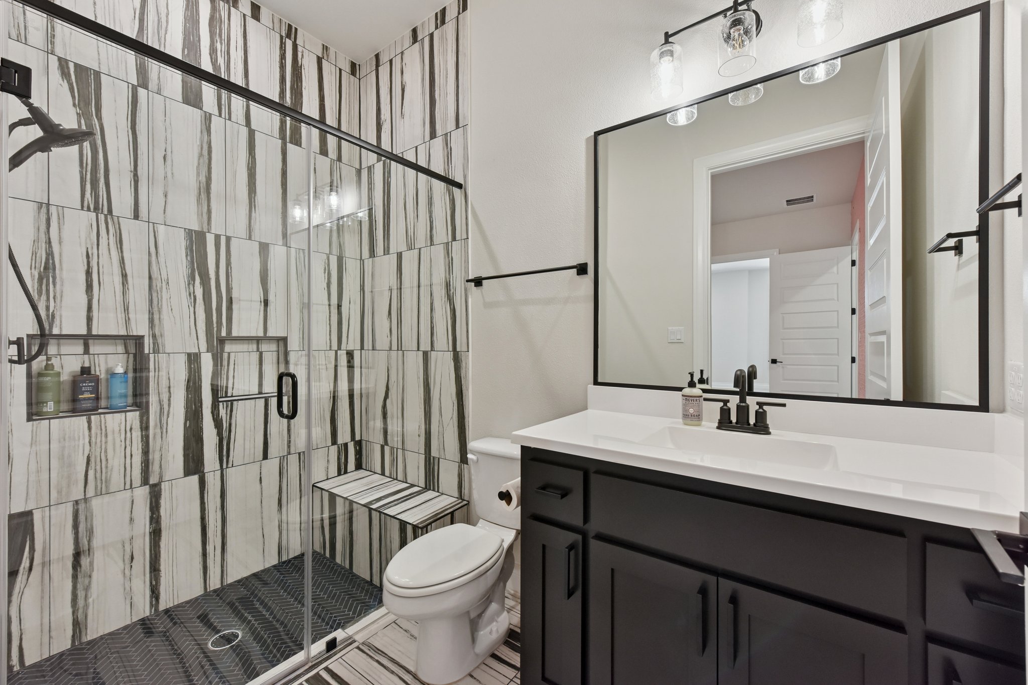222 Rio Ranchero Road Georgetown, TX 78628 - Photo 17 of 40 a bathroom with a sink a toilet a mirror and shower