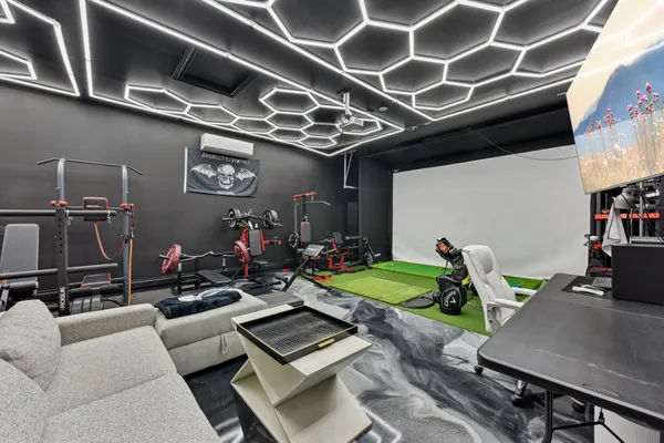 a living room with furniture and a gym machine