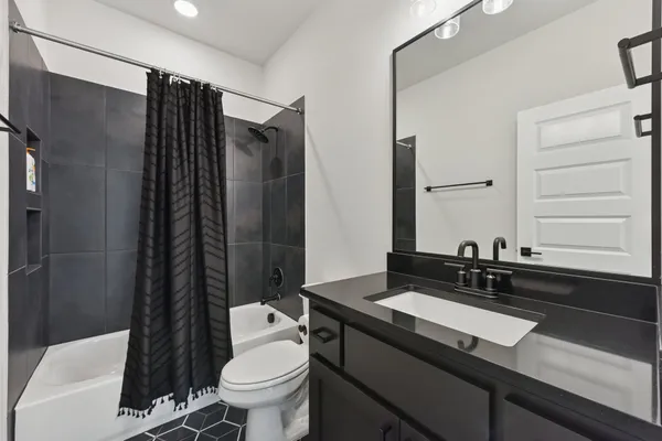 a bathroom with a sink a toilet a mirror and shower
