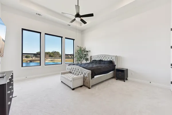 a spacious bedroom with a bed couch and window