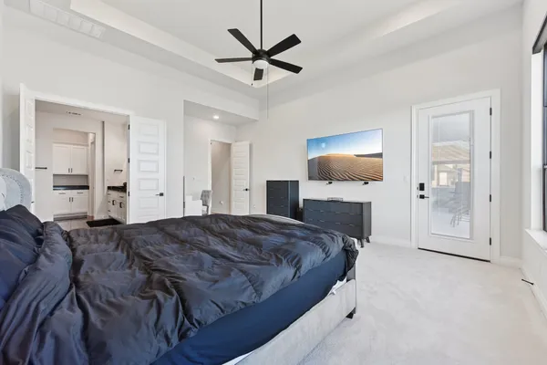 a spacious bedroom with a bed and a chandelier