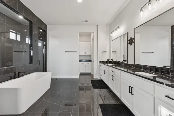 a large white bathroom with a double vanity sink a large mirror and a shower
