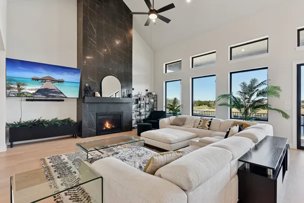 a living room with furniture a fireplace and a floor to ceiling window