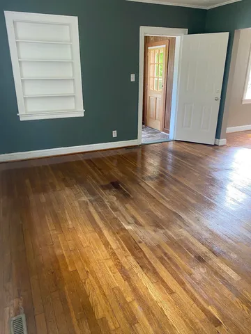a view of a room with wooden floor and windows