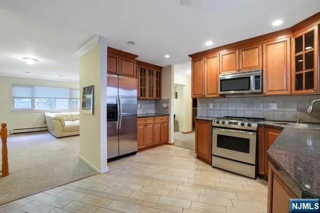 a kitchen with granite countertop a refrigerator and a stove top oven