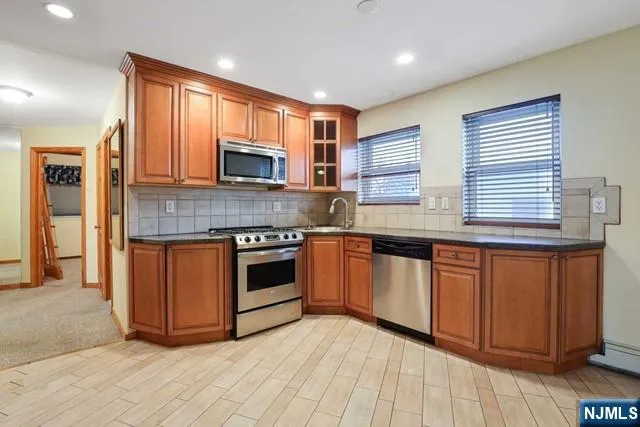 a kitchen with stainless steel appliances granite countertop wooden cabinets a sink and a stove