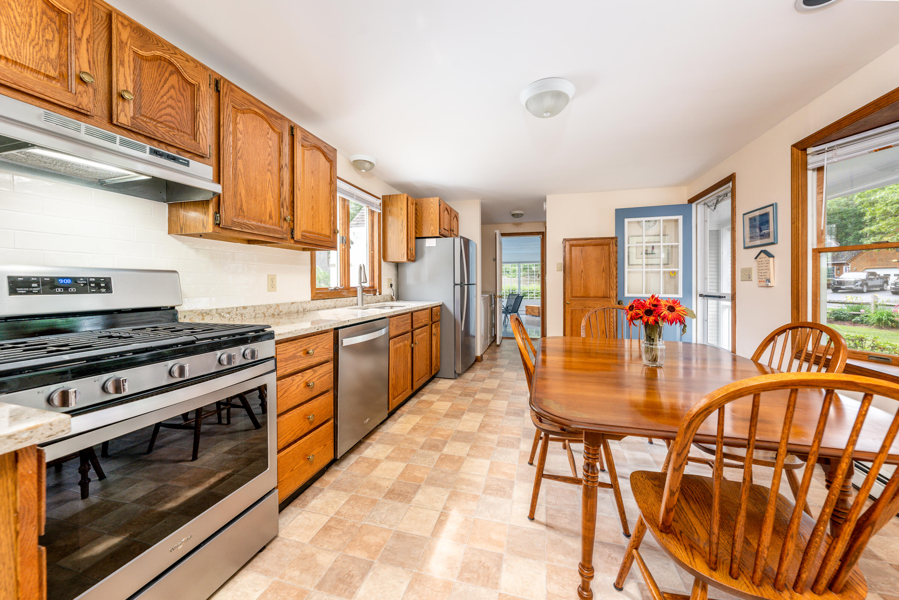 4 Leaf Lane Eastham, MA 02642 - Photo 17 of 39 a kitchen with stainless steel appliances granite countertop a stove a sink dishwasher a dining table and chairs with wooden floor