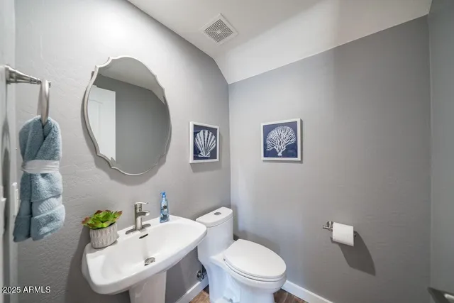 a bathroom with a toilet a sink and mirror