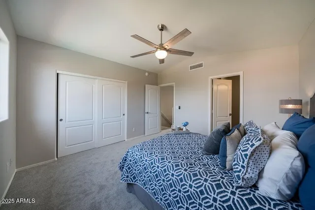 a living room with a bed and a ceiling fan